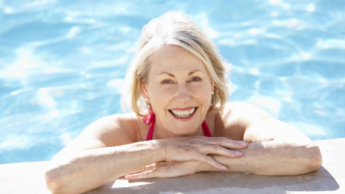 Senior Woman Relaxing In Swimming Pool.