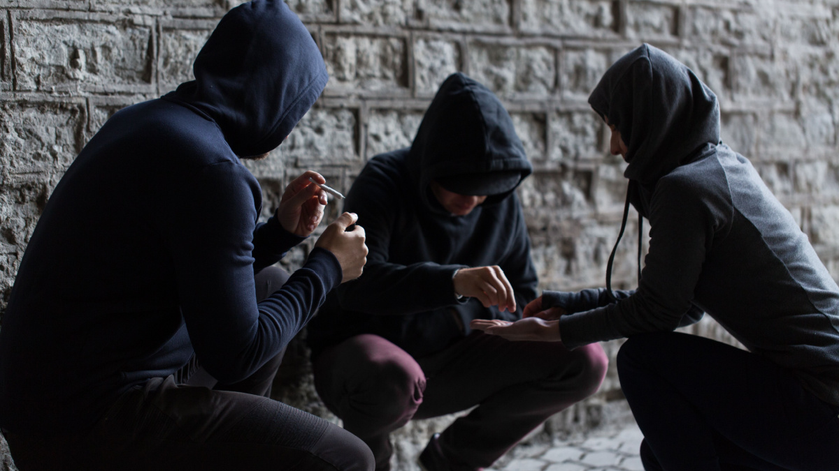 substance abuse, addiction and bad habits concept - close up of young people smoking cigarettes and using drugs outdoors