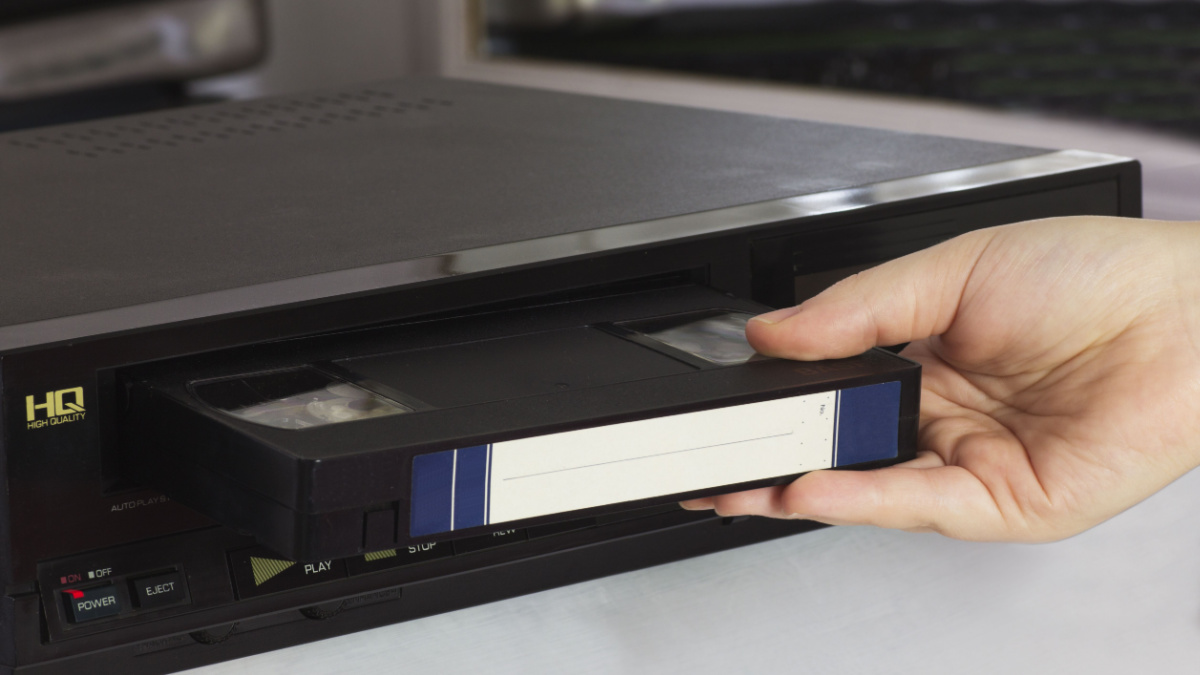 Female Hand Puts Old Video Tape into the Old Video Player.