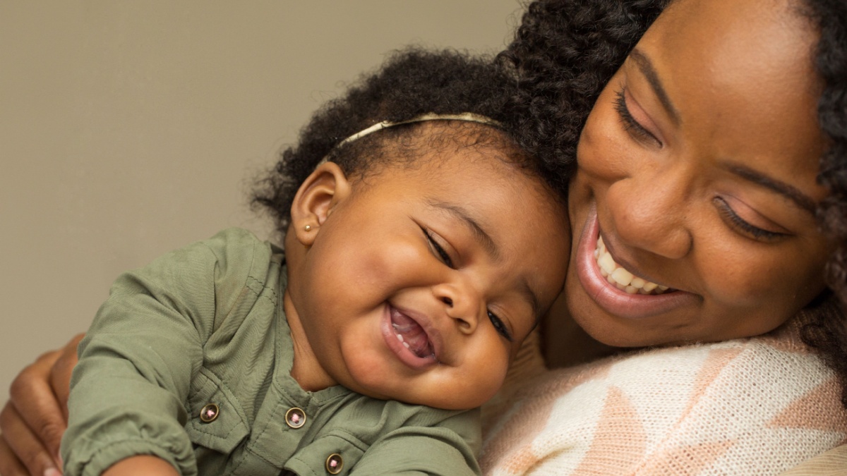 Portrait of woman relaxing at home with her little girl.