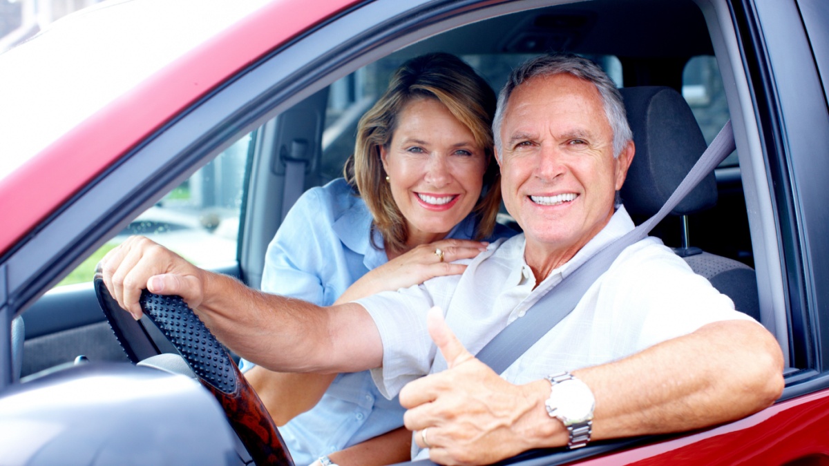 Smiling happy elderly couple in the car.