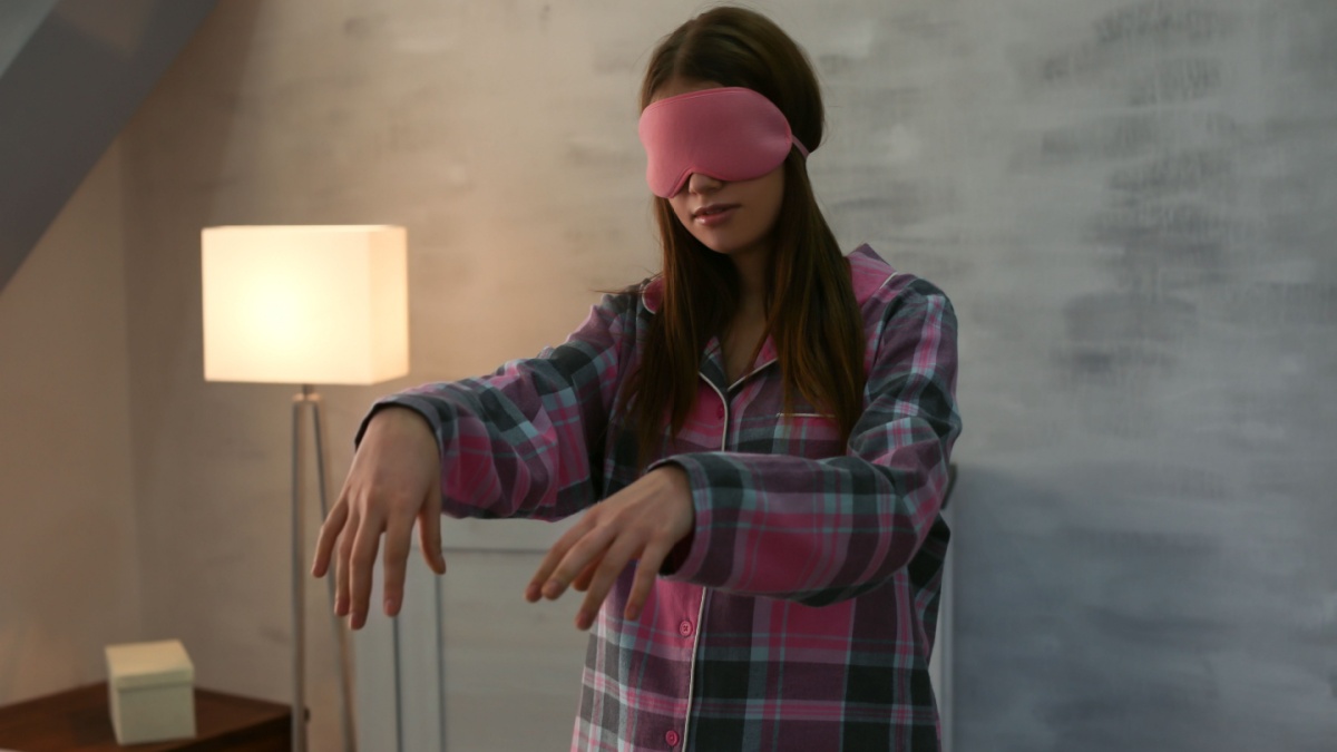 Young sleepy woman suffering from somnambulism at home
