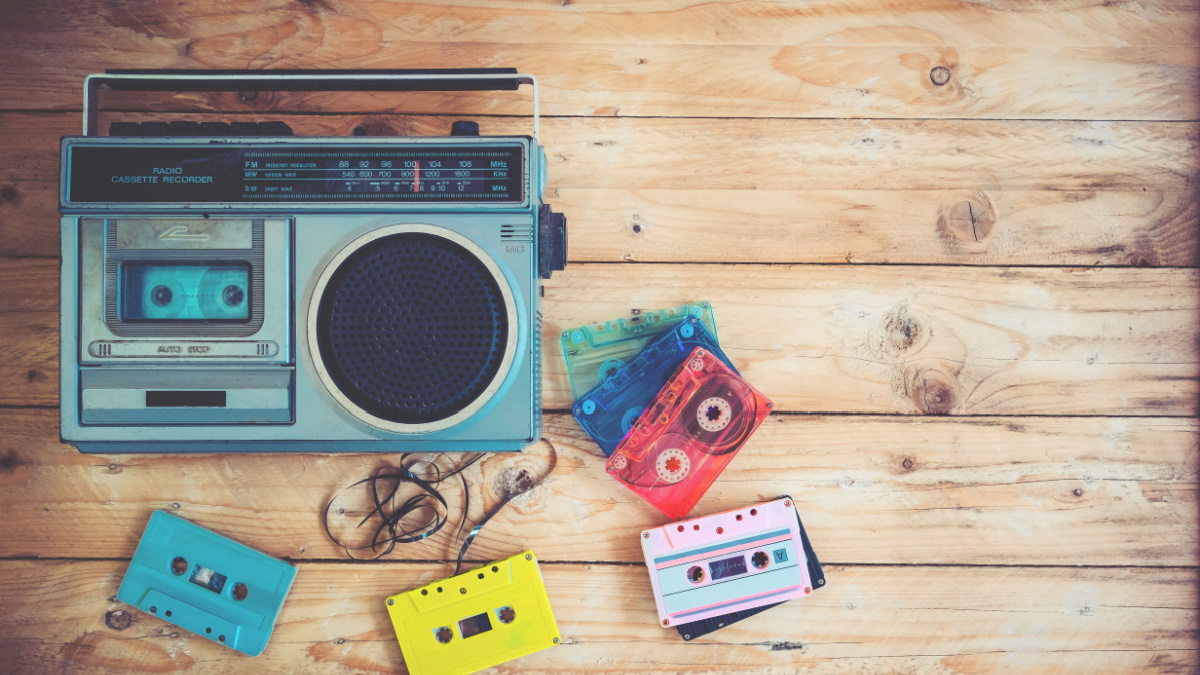 retro technology of radio cassette recorder music with retro tape cassette on wood table. Vintage color effect styles.