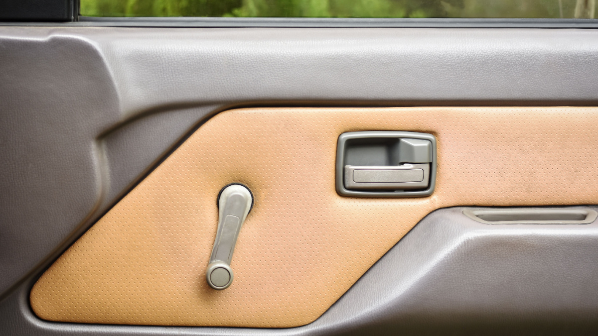 Refinishing inside of car door panel in beige color and equipped with original manual handle and window regulator.