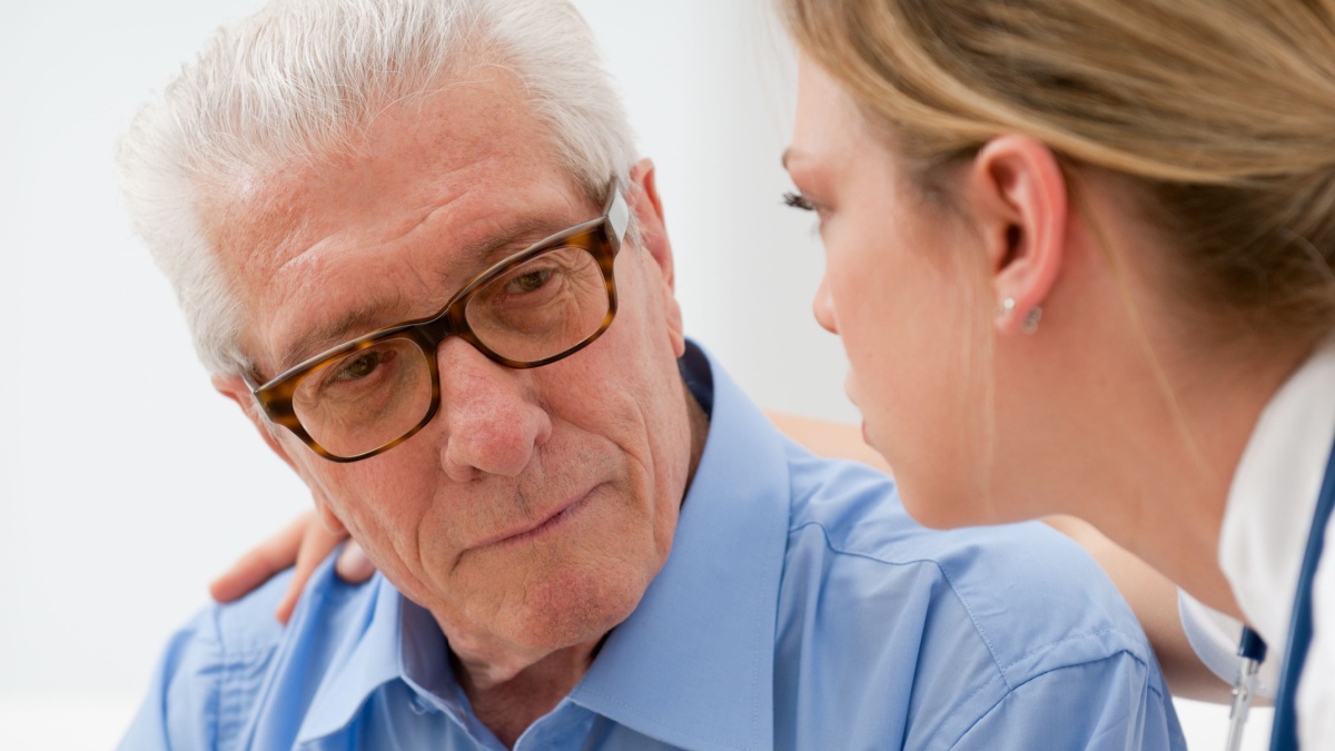 Sad and lonely senior man with nurse.