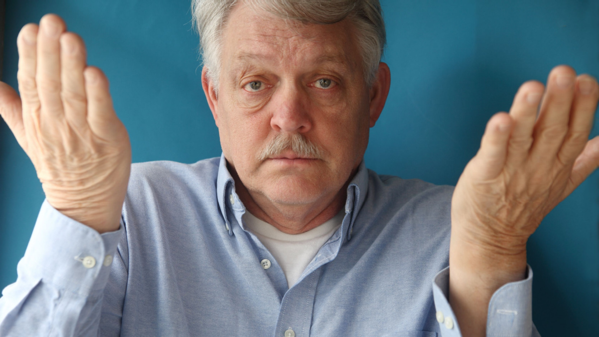 businessman uses body language to convey giving up, ignorance, indifference or uncertainty.