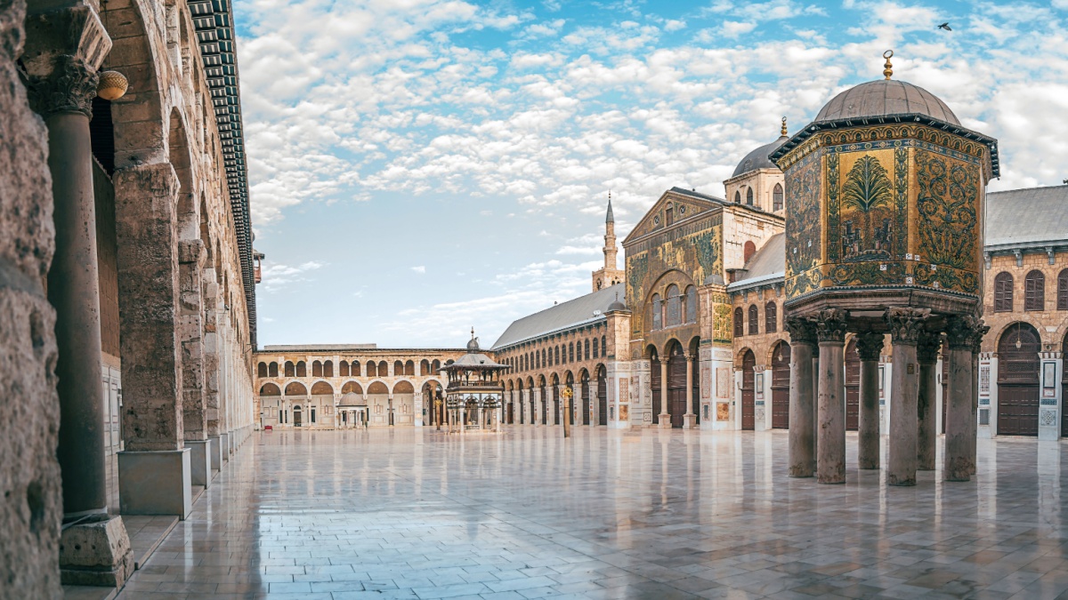day panoramic view of the umayyad mosque under the blue sky and white clouds. showing the islamic architecture and islamic art in this holy place in damascus syria.