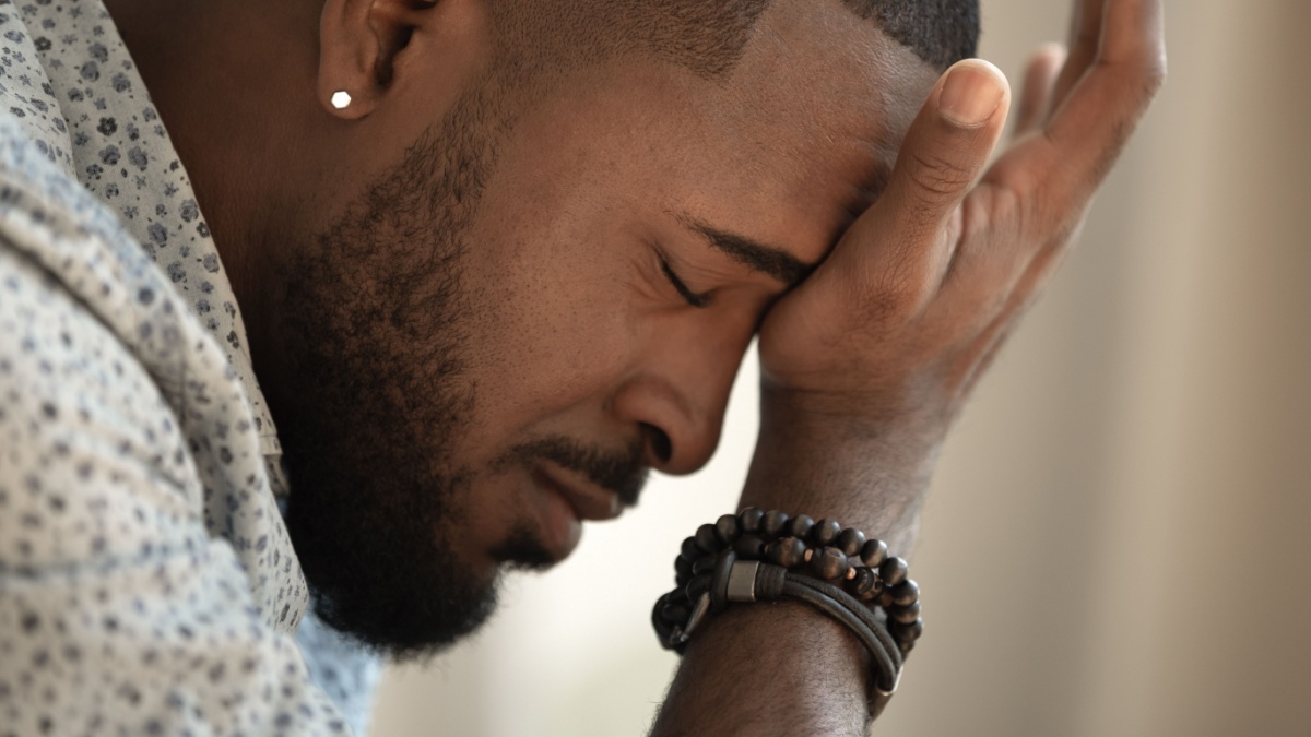 Upset stressed young african american man coping with strong headache concept, upset exhausted black guy feeling frustrated depressed tired touching.