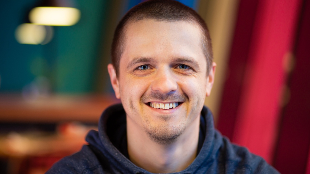 Portrait of male looking in camera and smiling.