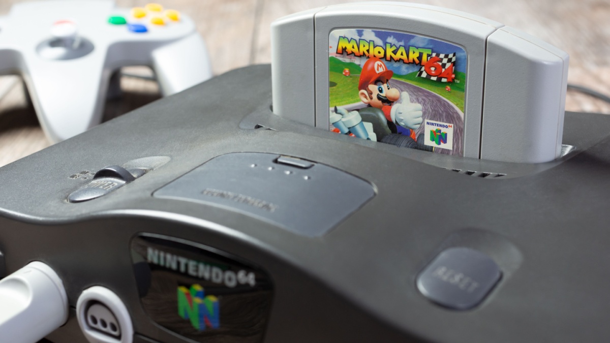 A closeup view of a Nintendo 64 game console, featuring the Mario Kart 64 game cartridge.