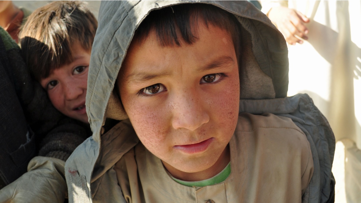 GHAZNI, AFGHANISTAN - November 22, 2010: An Afghan boy poses for a photo and waits in anticipation of seeing his image on the camera's LCD screen.