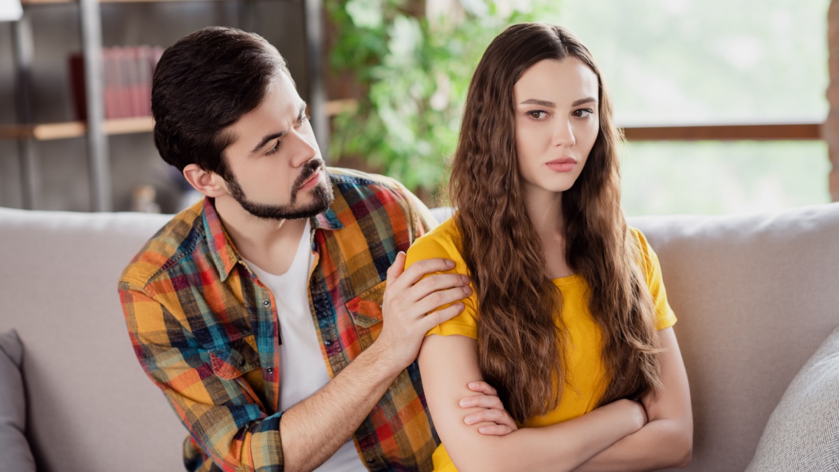 Photo of upset couple bearded man try comfort offended girlfriend wear casual clothes sit couch home indoors.