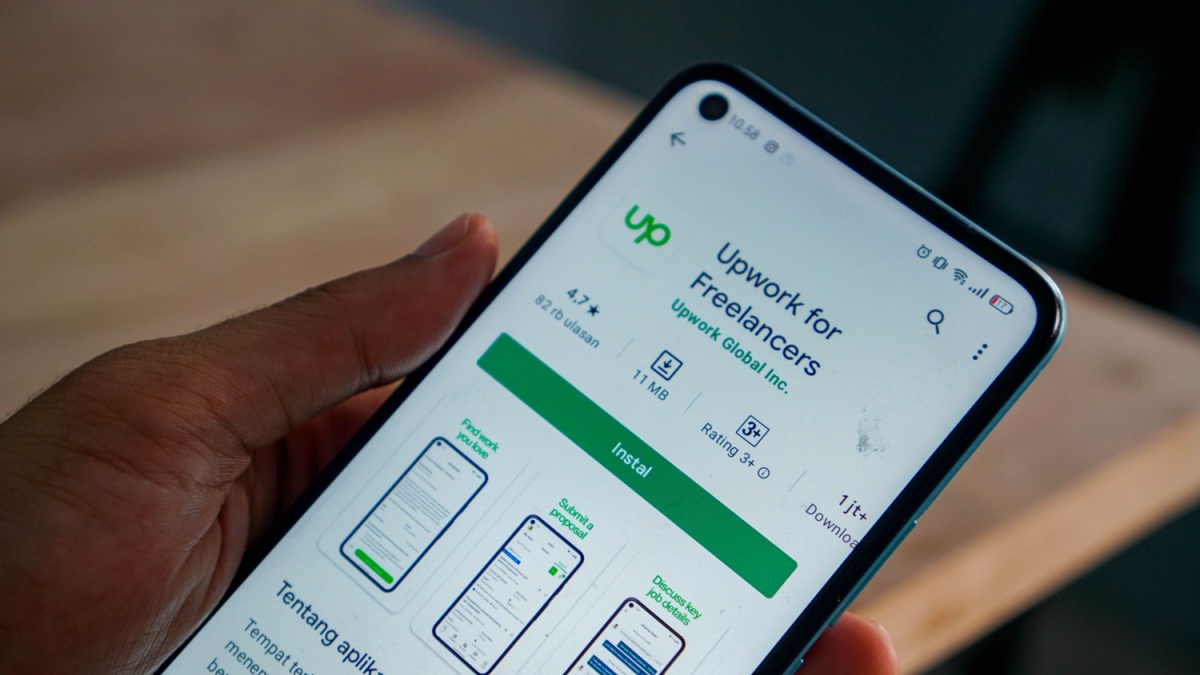 Upwork app on android. hand holding smartphone opens upwork app. freelance app