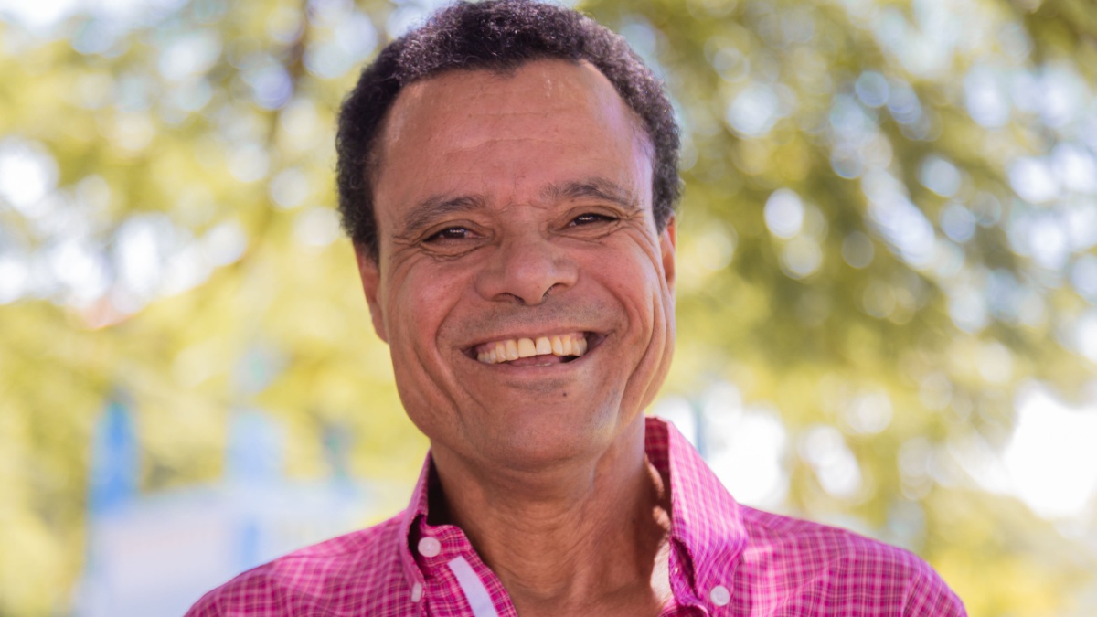 Portrait of smiling beautiful older male farmer. Elderly man at farm in summer day. Gardening activity. Brazilian elderly man.