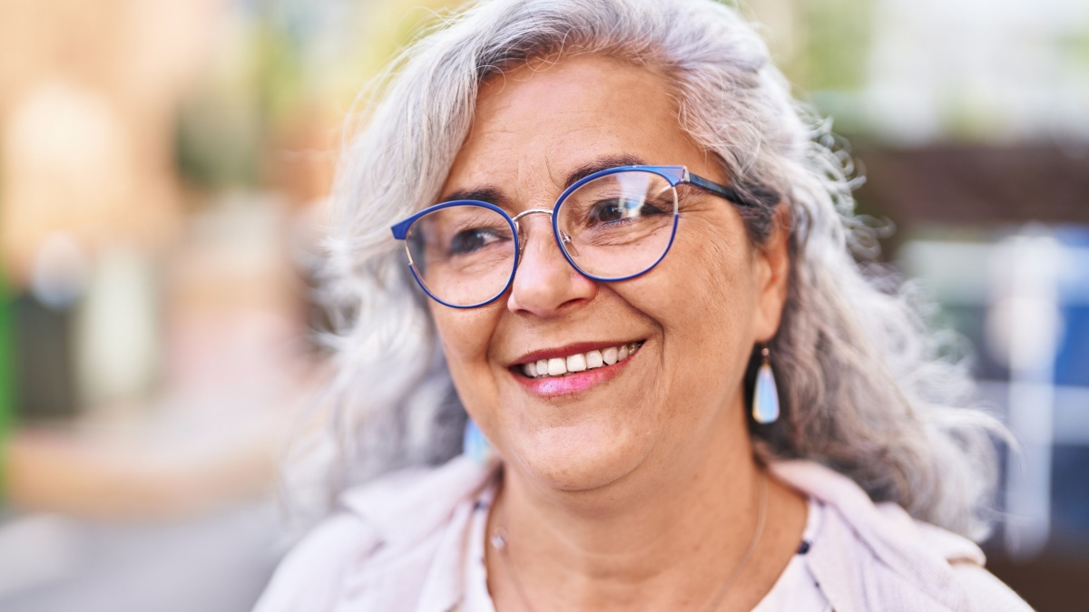 Middle age woman smiling confident standing at street.