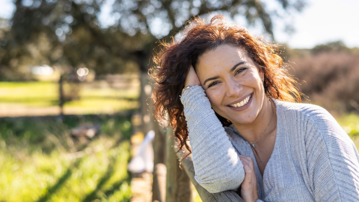 Happy Woman Smiling At Camera In A Field.