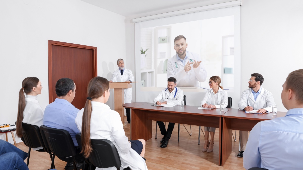 Lecture with online participant. Doctors in meeting room. Using projector for videoconference