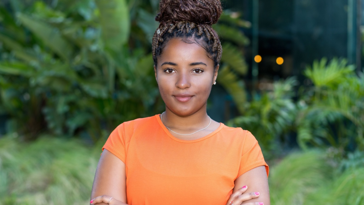 Portrait of young adult woman from Africa with orange shirt.
