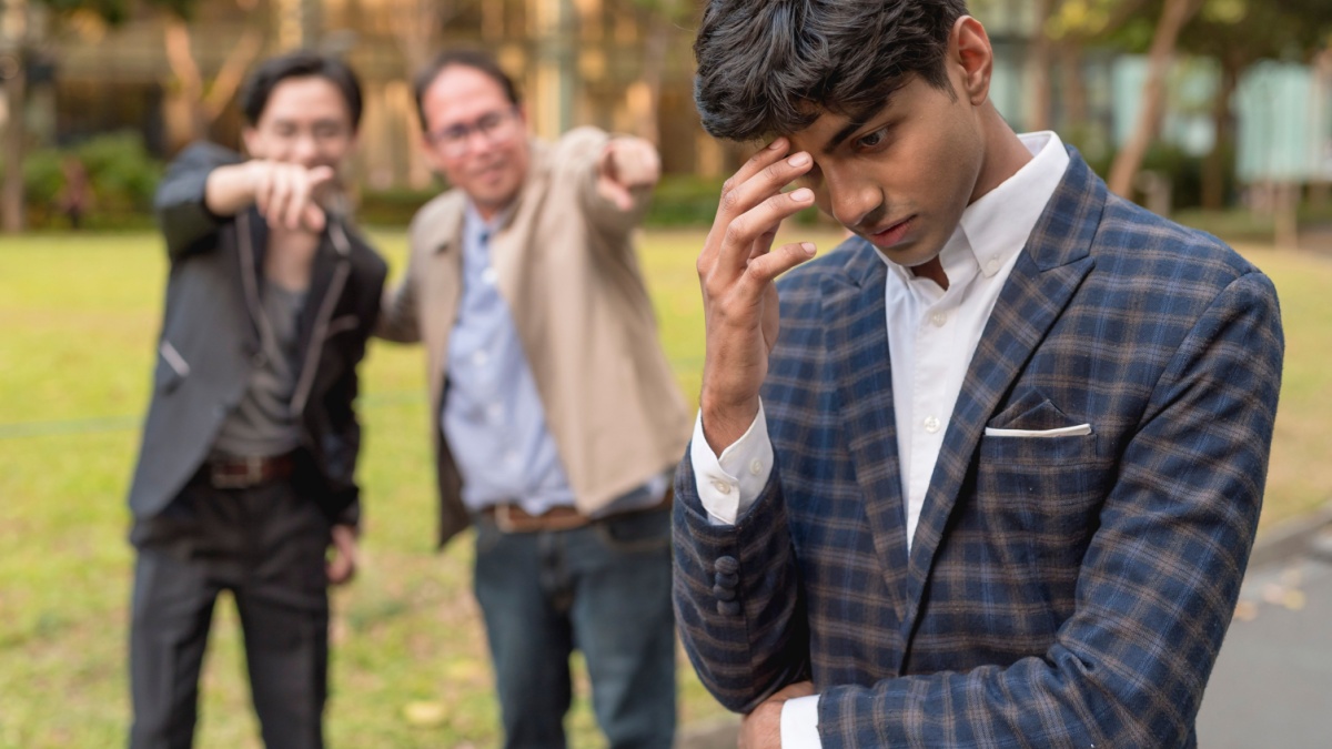 A young man feels depressed after being made fun of or being mocked by his colleagues. Feeling ashamed and ostracized. Possible racial discrimination.