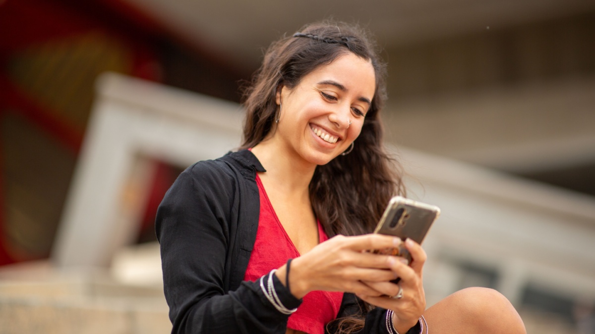 Portrait smiling woman sitting with mobile phone.