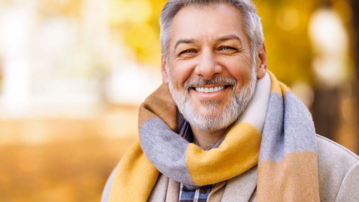 20 Essential Habits for a Longer, Healthier Life 16 Portrait of happy positive mature man with broad smile in elegant clothes on an autumn walk in city park.