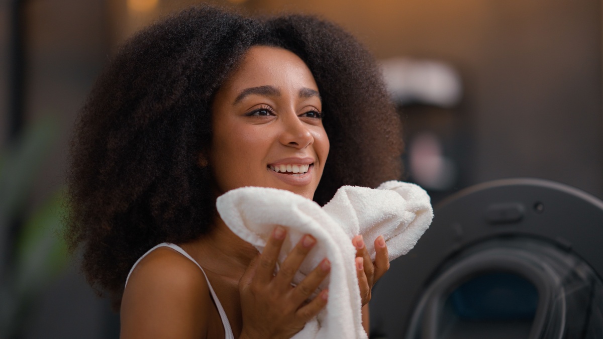 African American girl ethnic lady biracial woman housewife home work routine good smell laundry clothes open washing machine housekeeping.