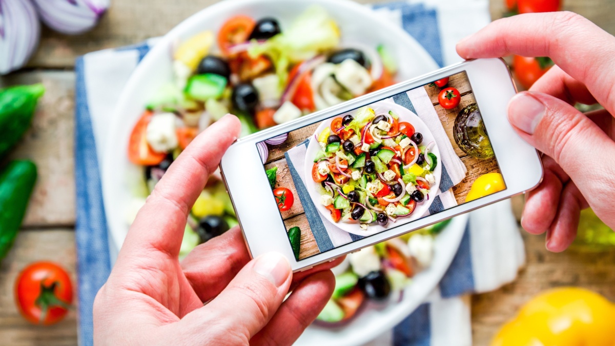 Smartphone taking picture from organic greek salad