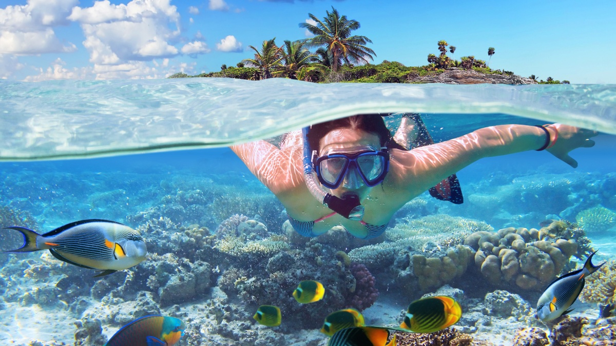 Young woman at snorkeling in the tropical water