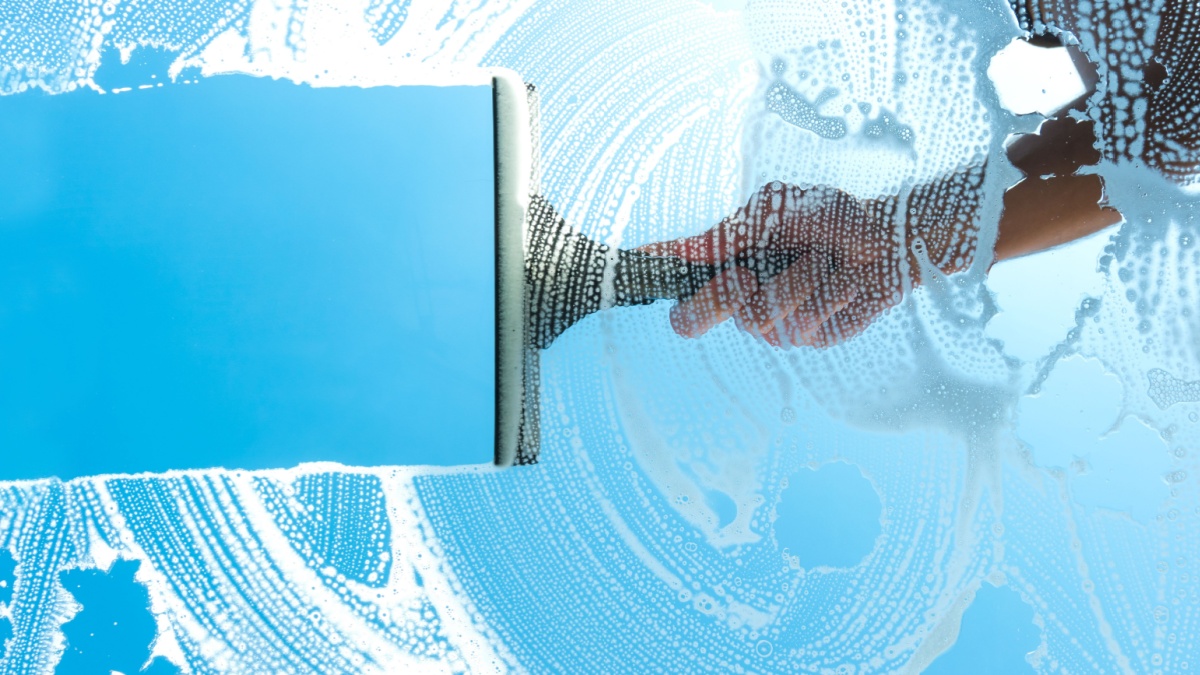 cleaning window with squeegee blue sky.