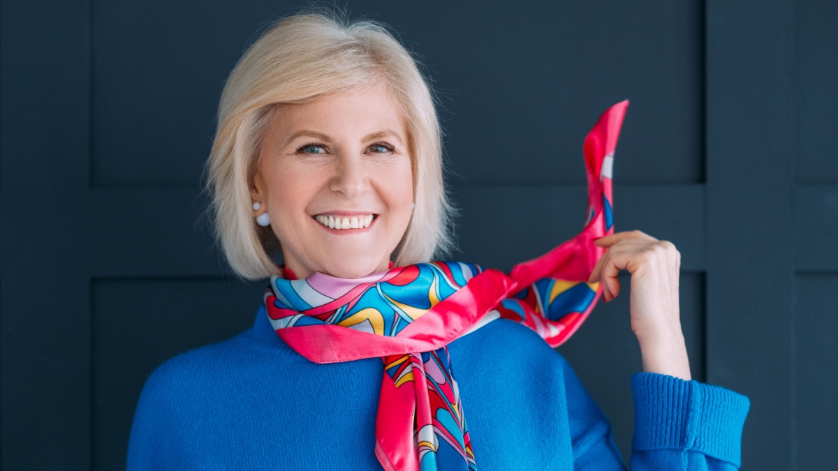 Aged lady style. Accessories. Wardrobe essentials and fashion trends. Smiling female in blue pullover touching neckerchief.