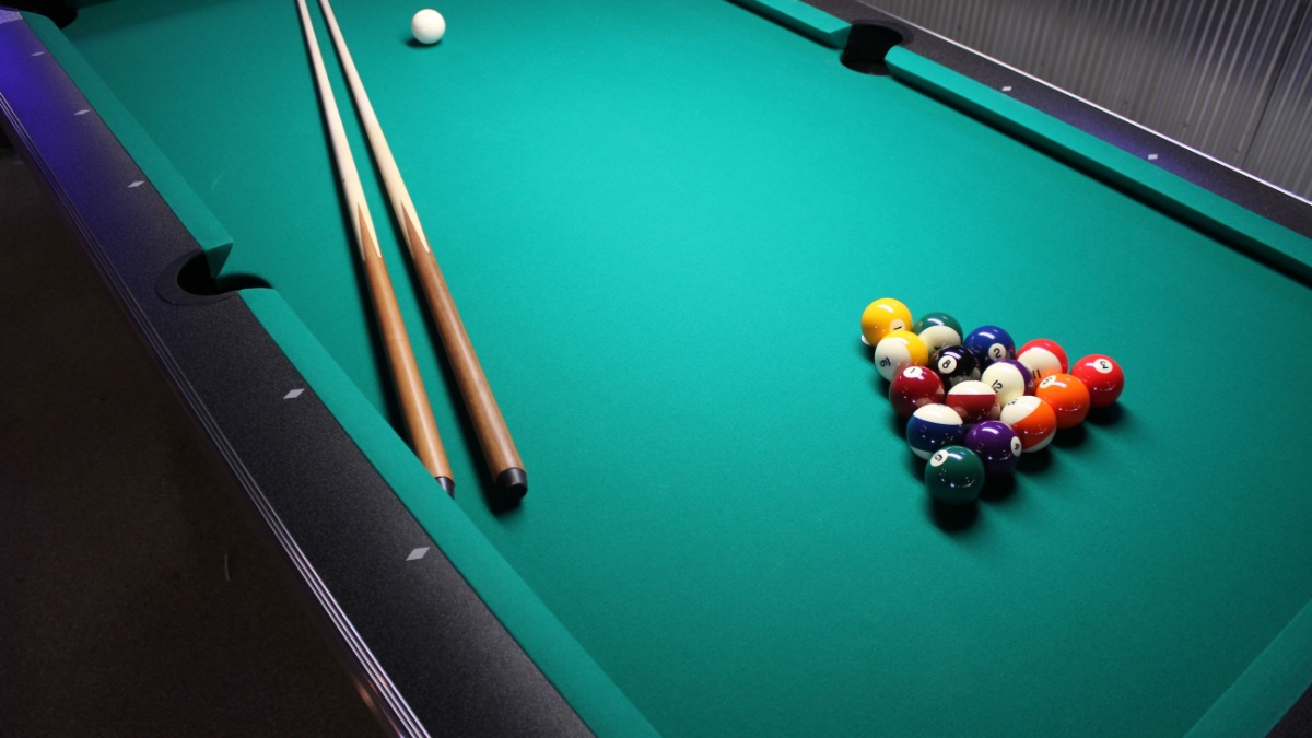 A Pool Table, set up for a game - A game of 8 Ball, racked and ready to go!