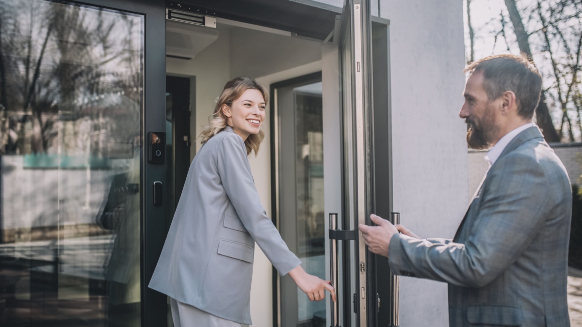 Woman entering office and man opening door