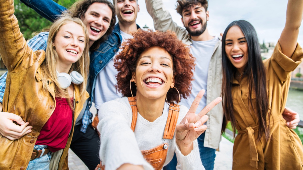 Multiracial group of friends taking selfie pic outside - Happy different young people having fun walking in city center.