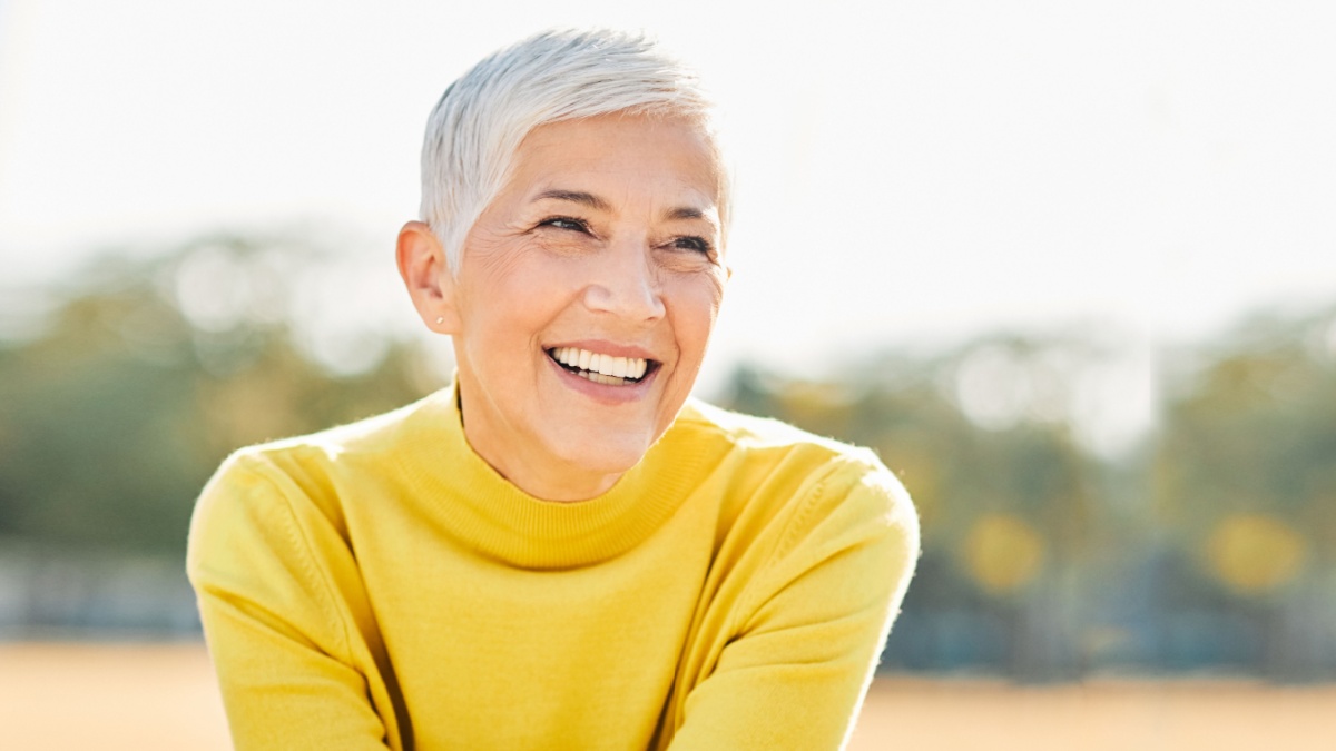 Portrait of an elderly woman outdoors. Happy senior woman in park.
