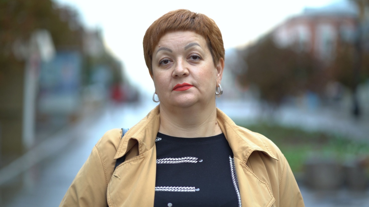 Portrait of a sad upset woman standing on the street and looking at the camera.