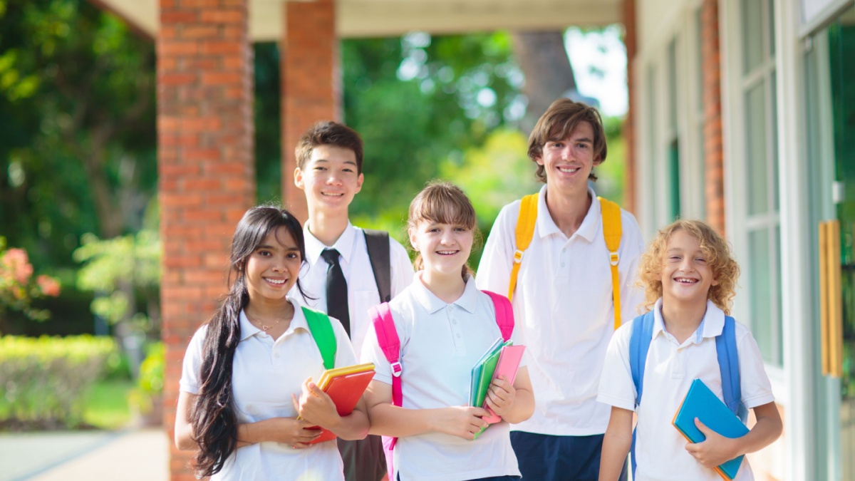 Kids go back to school. Interracial group of children of mixed age on the first day of new academic year.