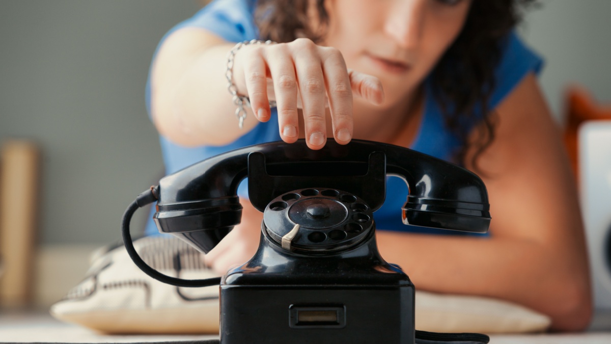 prominent black vintage rotary phone in focus epitomizes the direct nature of voice calls.