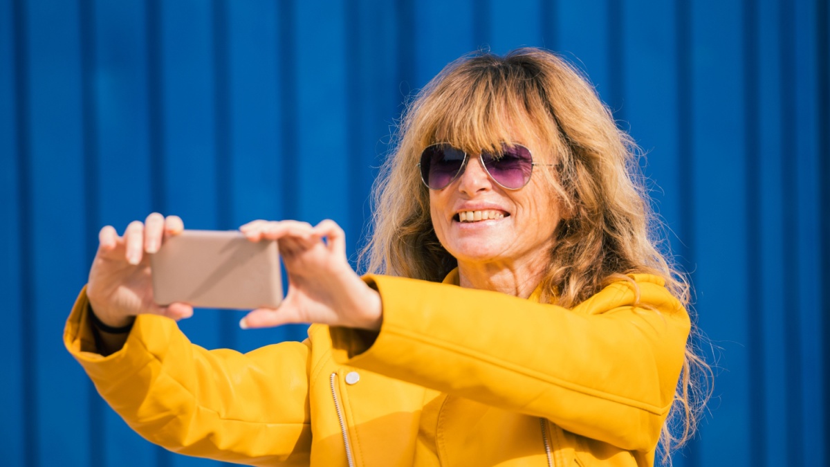 middle-aged adult woman using mobile phone outdoors.