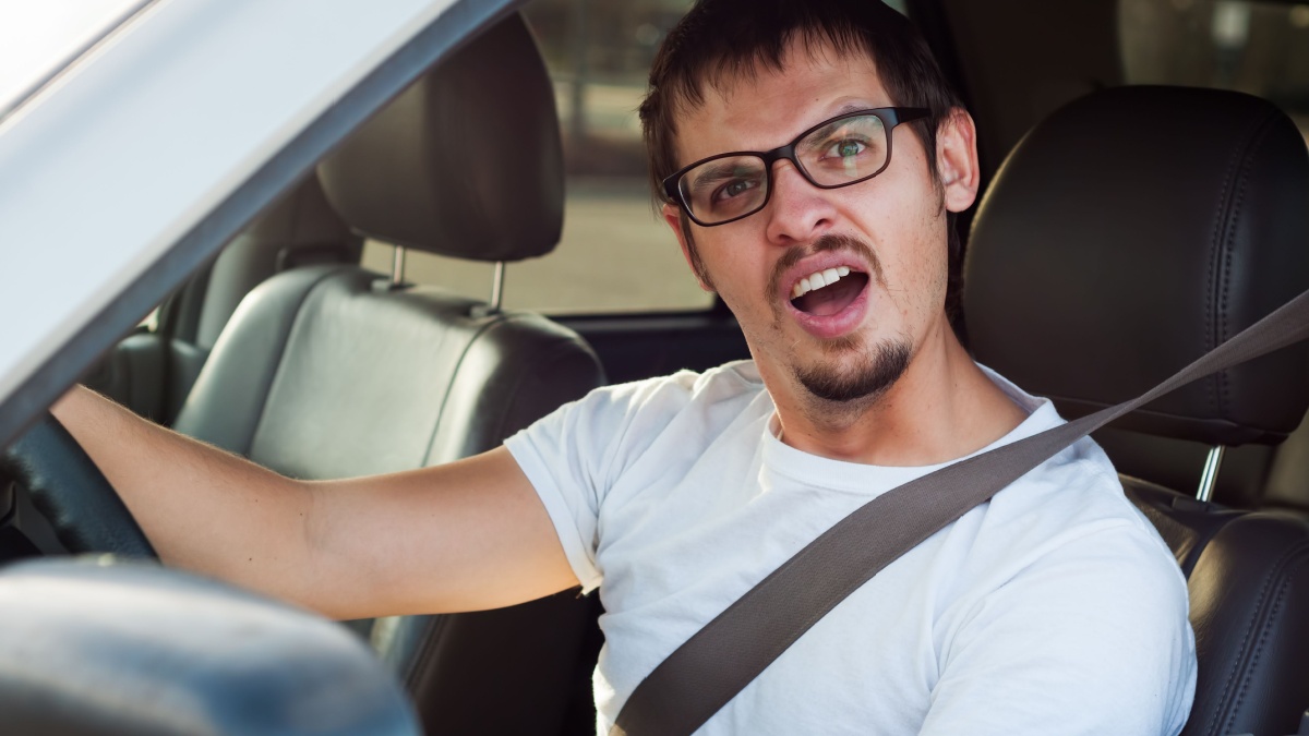Male stupid face european driver is opening his mouth.