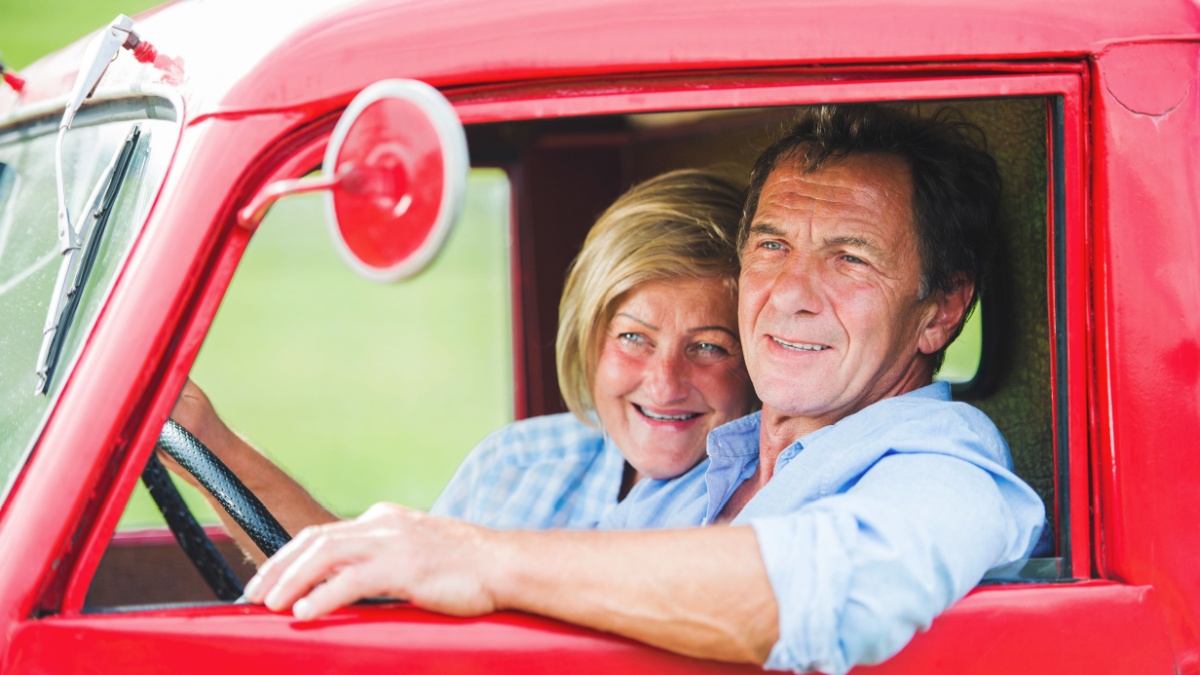 Senior couple in red car.