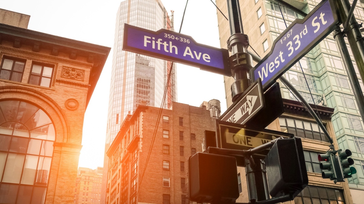 Street sign of Fifth Ave and West 33rd St at sunset in New York City - Urban road concept direction in Ny Manhattan downtown - American world famous capital destination on warm dramatic filtered look
