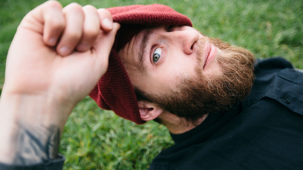 Hipster man smiling and wearing a hat.