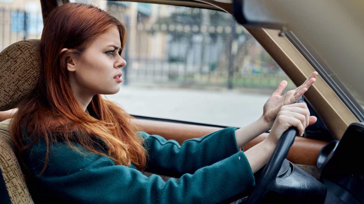 A brunette woman driving a car.