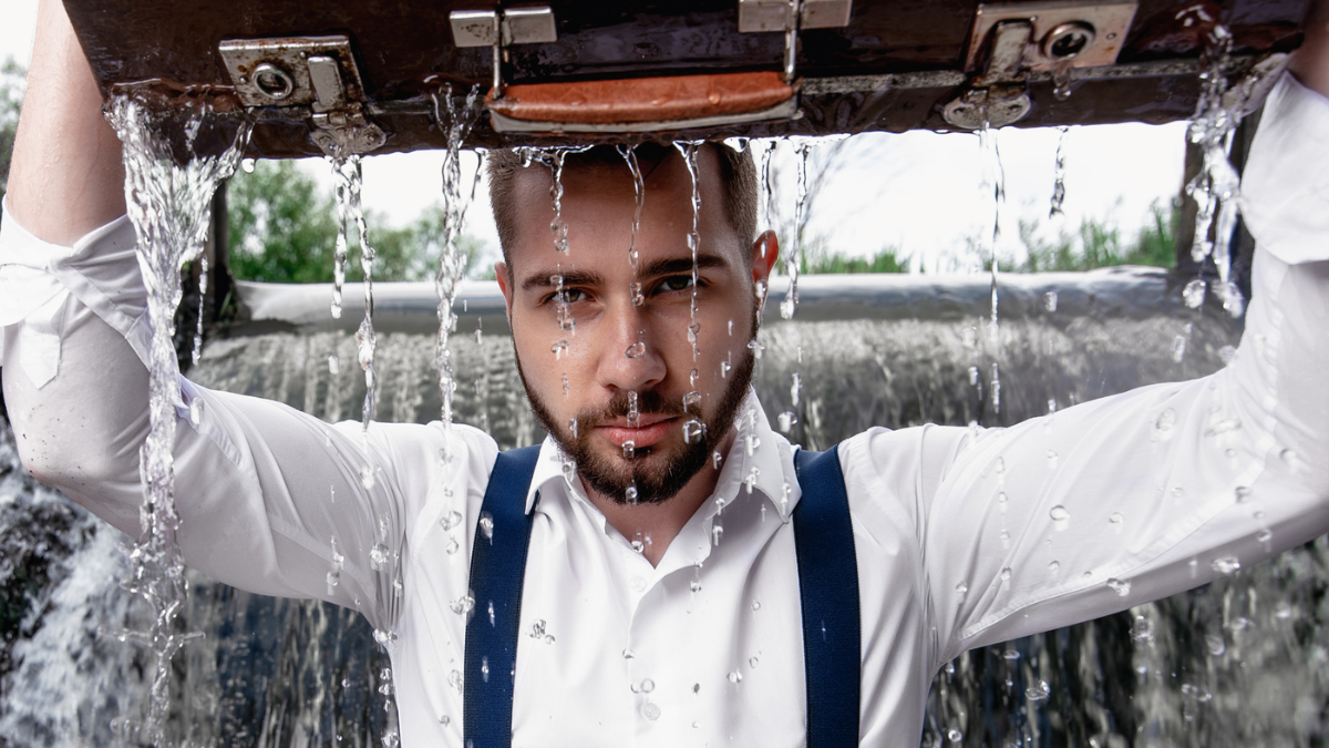 Bearded man concentrated with suitcase in water.