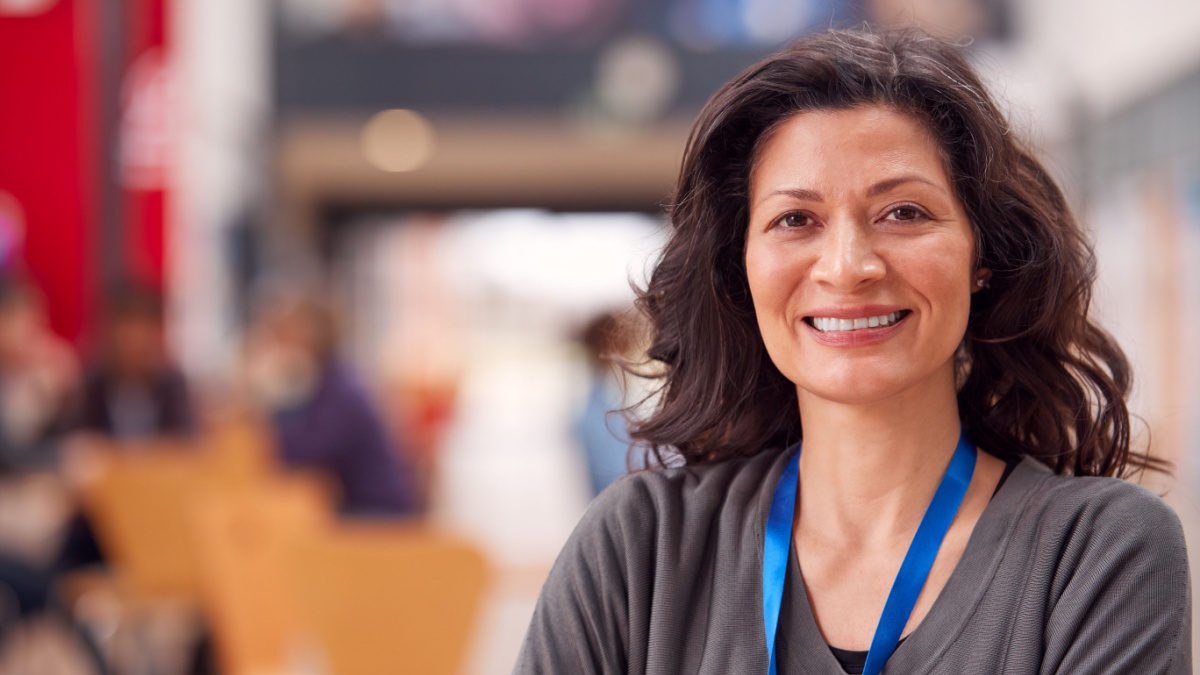 Portrait Of Mature Female Teacher Or Student In College Hall.