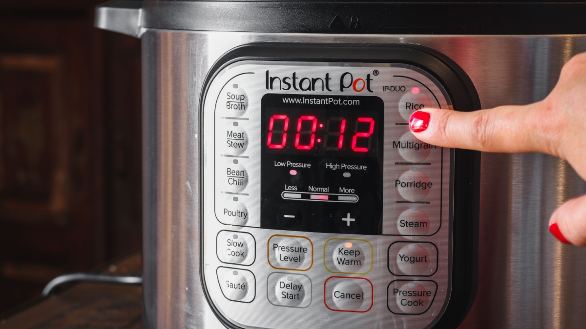 Walvis Bav / Namibia - 10/06/2020: Clicking one of instant pot buttons while cooking in the kitchen.